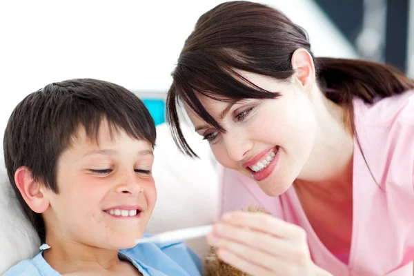Smiling nurse and his patient looking at a thermometer — Stock Photo, Image