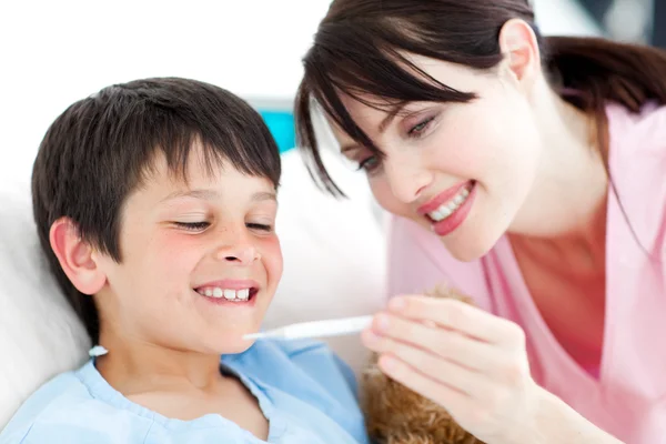 Positive nurse and his patient looking at a thermometer — Stock Photo, Image