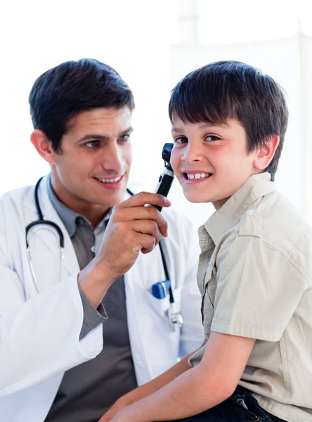 魅力的な医師の小さな男の子の耳を調べる — ストック写真