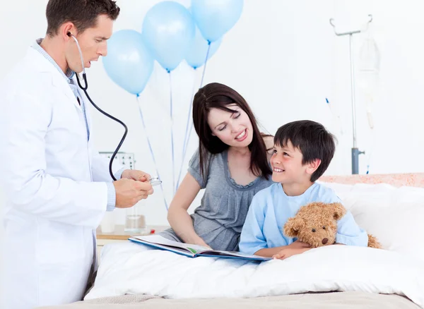 Aufmerksame Ärztin im Gespräch mit einem kleinen Jungen und seiner Mutter — Stockfoto