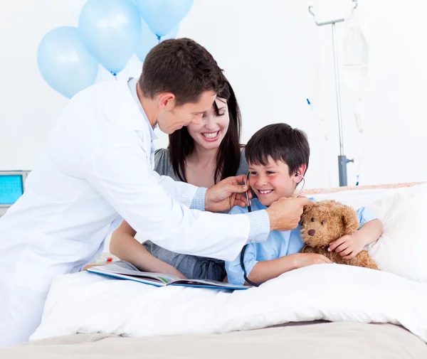 Sorridente medico giocare con un bambino e sua madre — Foto Stock