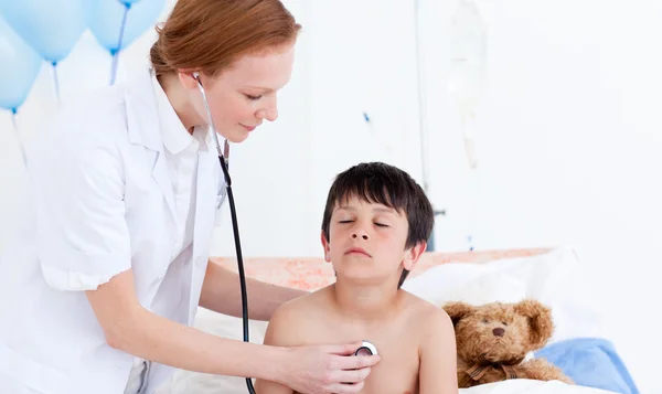 Médico bonito examinando um menino — Fotografia de Stock
