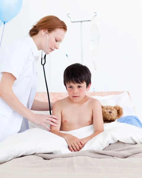 Schöne Ärztin untersucht einen kleinen Jungen — Stockfoto