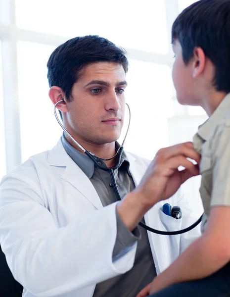 Portrait of a serious doctor examining a little boy — Stock Photo, Image