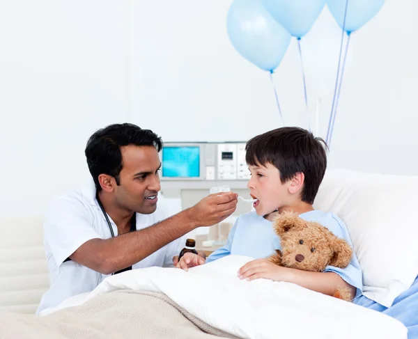 Uppmärksam läkare att ge medicin till en liten pojke — Stockfoto