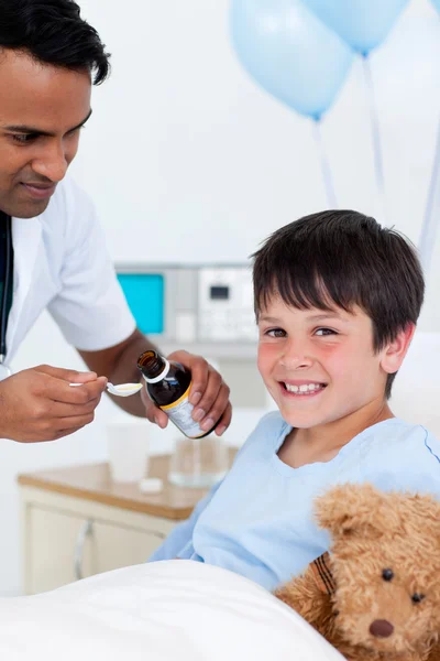 Θετική γιατρός δίνει ιατρική σε ένα μικρό αγόρι — Φωτογραφία Αρχείου