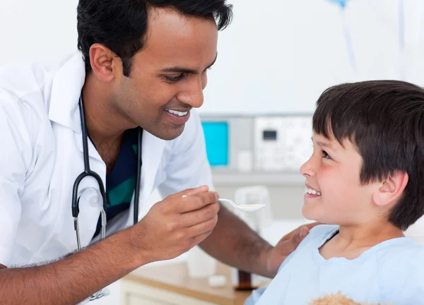 Schöner Arzt gibt einem kleinen Jungen Medizin — Stockfoto