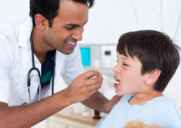 Χαρισματικός γιατρός δίνει ιατρική σε ένα μικρό αγόρι — Φωτογραφία Αρχείου