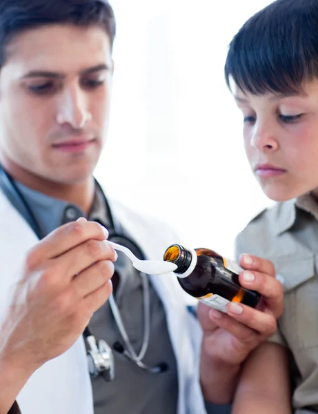 Συμπυκνωμένο γιατρός δίνει ιατρική σε ένα μικρό αγόρι — Φωτογραφία Αρχείου