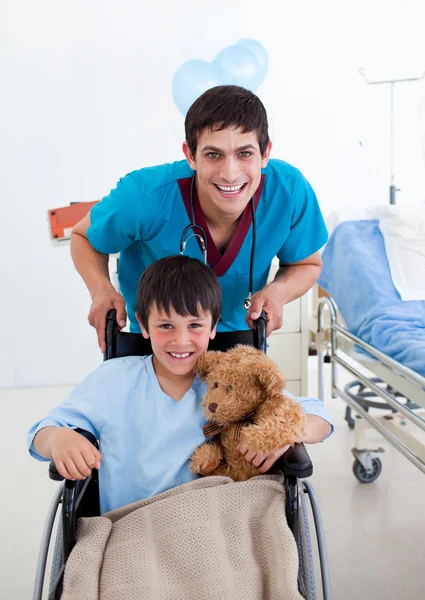 Портрет маленького мальчика, сидящего на инвалидной коляске и врача — стоковое фото