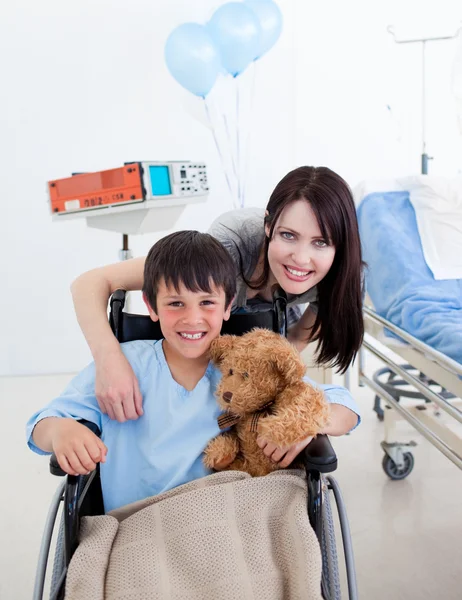 Uśmiechnięty chłopczyk siedział na wózku inwalidzkim i jego matka — Zdjęcie stockowe