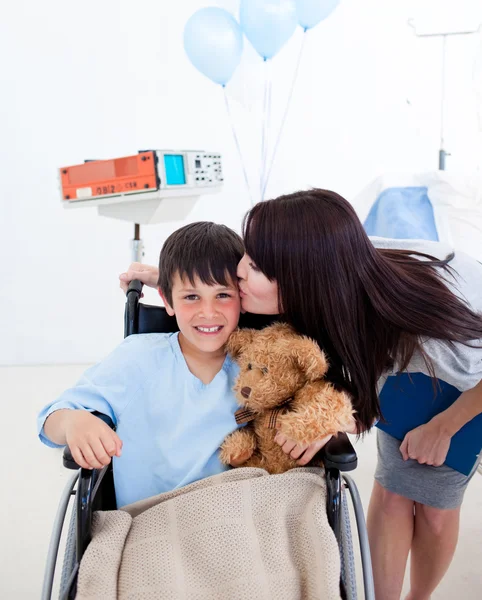 Wesoły chłopiec siedzi na wózku inwalidzkim i jego matka — Zdjęcie stockowe