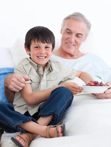 Affectionate little boy taking care of his grandfather — Stock Photo, Image