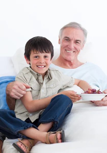 Cute little boy taking care of his grandfather — Stock Photo, Image