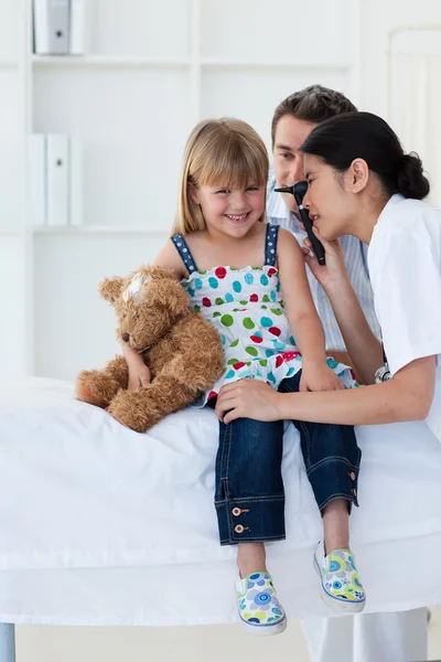 Serious patient examing littl girl's ears — Stock Photo, Image