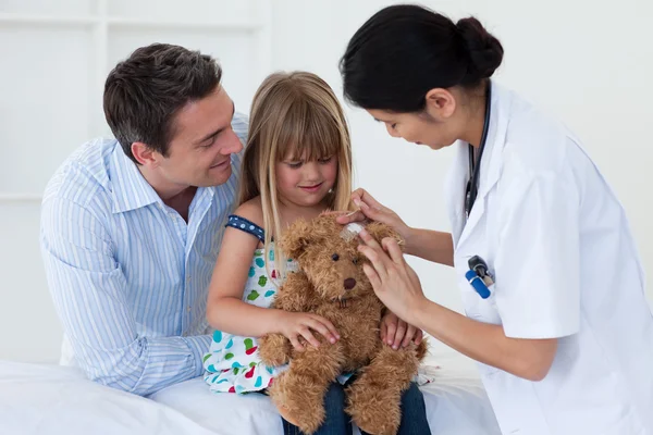 Porträt eines Arztes und eines kleinen Mädchens bei der Untersuchung eines Teddybären — Stockfoto