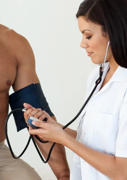 Крупним планом жінка-лікар, яка перевіряє кров'яний тиск — стокове фото