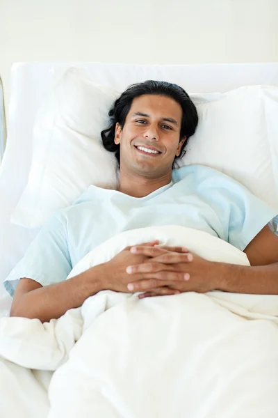 Retrato de um paciente sorridente deitado em uma cama de hospital — Fotografia de Stock