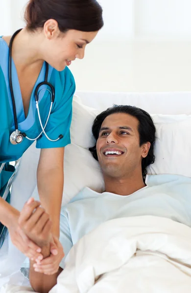 Lekarz bada pacjenta leżącego na łóżku szpitalnym — Zdjęcie stockowe