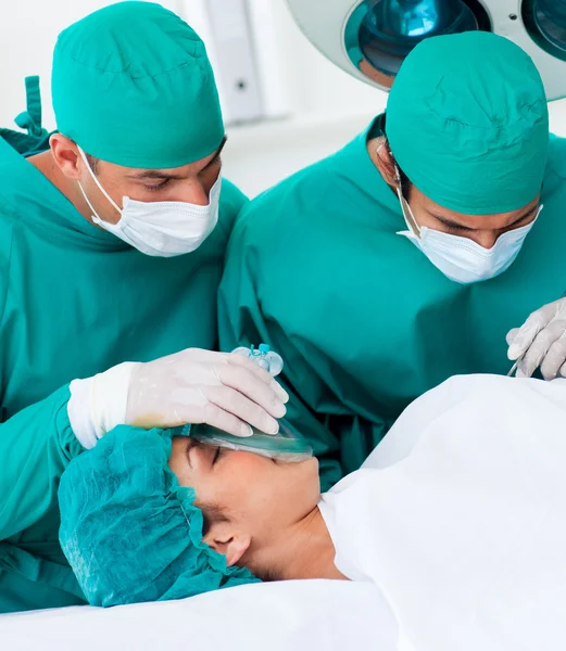 Крупный план хирургов рядом с пациентом лежащих на операционном столе — стоковое фото