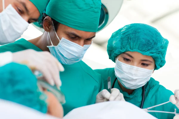 Cirurgiões multi-étnicos durante uma cirurgia — Fotografia de Stock