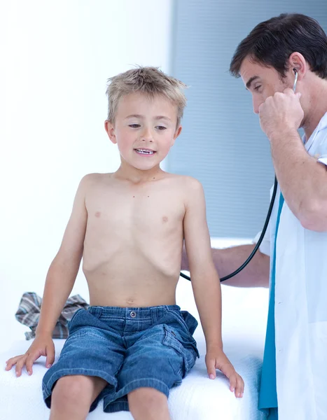 Médico examinando a un niño pequeño con estetoscopio — Foto de Stock