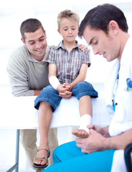 Médico enfaixando o pé de uma criança — Fotografia de Stock