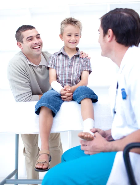 Medico bendaggio piede di un paziente con suo padre — Foto Stock