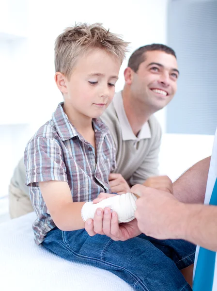 Bendaggio di una lesione al braccio su un bambino — Foto Stock
