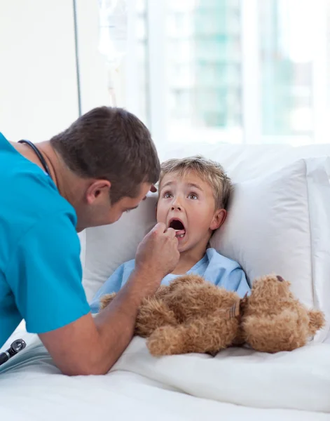Mužského lékaře vyšetřujícího dítě hrdlo — Stock fotografie
