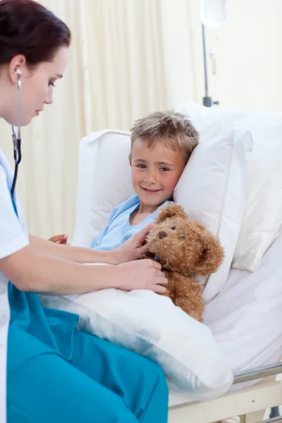 Ärztin hört einer Kinderbrust und einem Teddybär zu — Stockfoto