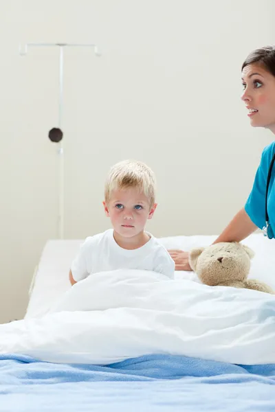 Portrait of a sick little boy on a hospital bed — Stock Photo, Image