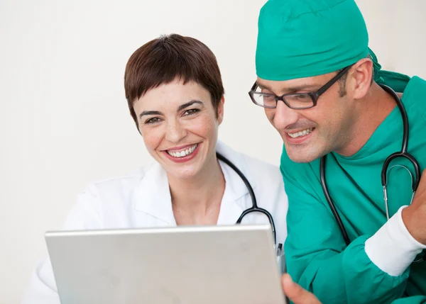 Arts en chirurg op zoek naar een laptop — Stockfoto