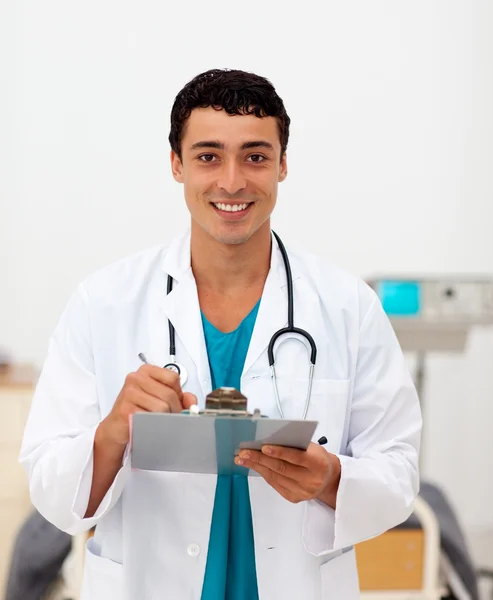 Junger männlicher Arzt hält ein Klemmbrett — Stockfoto