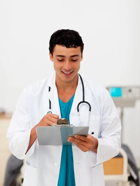 Junger männlicher Arzt hält ein Klemmbrett — Stockfoto