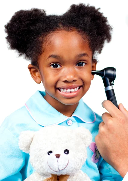 Smiling little girl attending medical check-up holding a teddy b — Stock Photo, Image