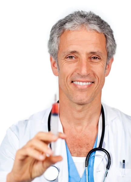 Улыбающийся доктор представляет шприц — стоковое фото