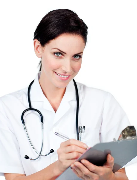 Uśmiechnięta kobieta lekarz pisania w schowku — Zdjęcie stockowe