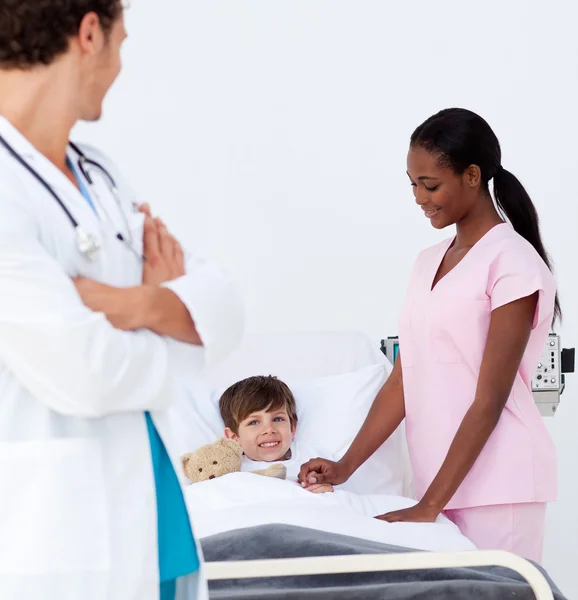 Педиатр и медсестра, ухаживающие за маленьким мальчиком — стоковое фото