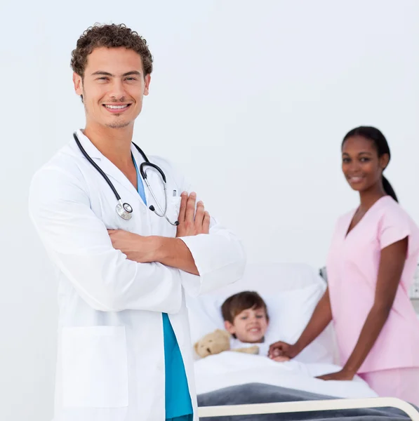 Confident pediatrician and nurse attending to a child — Stock Photo, Image