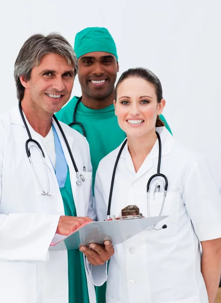 Lächelnde Ärzte und Chirurg machen sich Notizen — Stockfoto