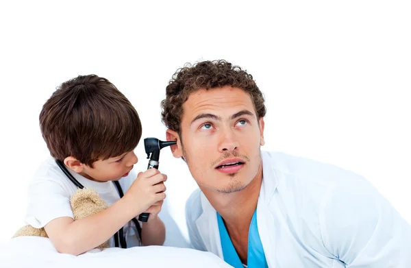 Милый мальчик проверяет уши доктора. — стоковое фото