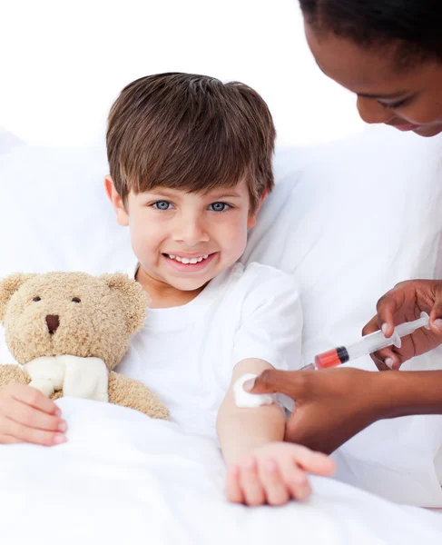 Smiling little boy receiving an injection — Zdjęcie stockowe
