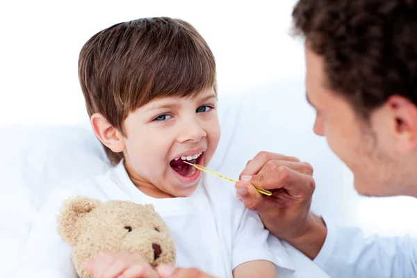 Médico joven tomando la temperatura del niño — Foto de Stock