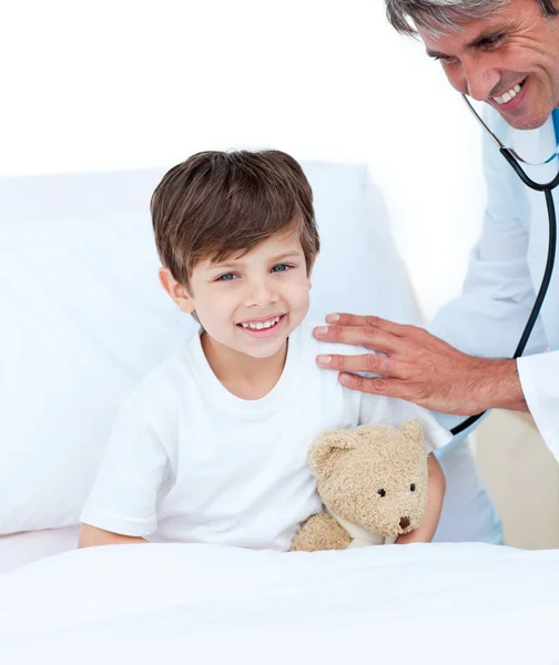 Médico sorrindo verificando o pulso do menino — Fotografia de Stock