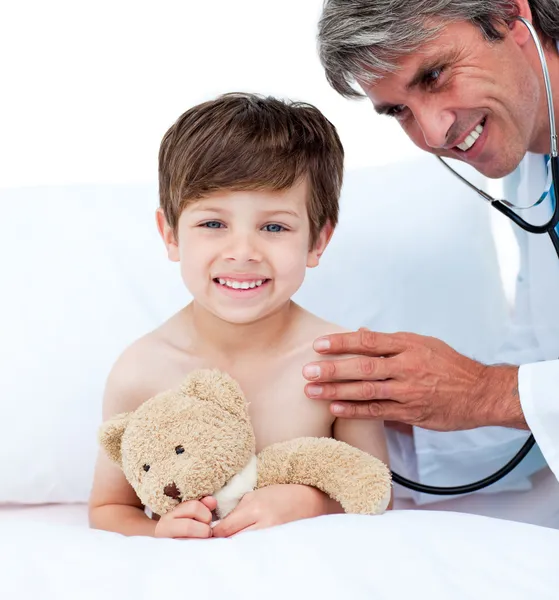 Médico maduro verificando o pulso do menino — Fotografia de Stock