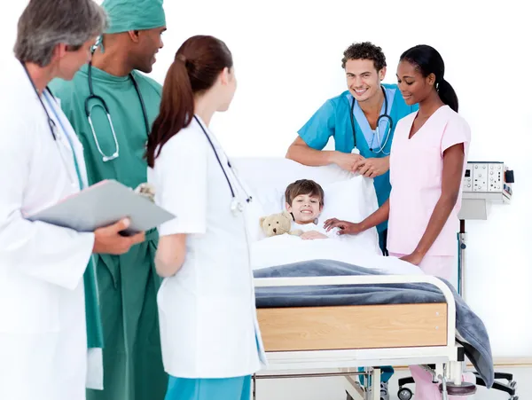 Equipo médico positivo cuidando de un niño pequeño —  Fotos de Stock