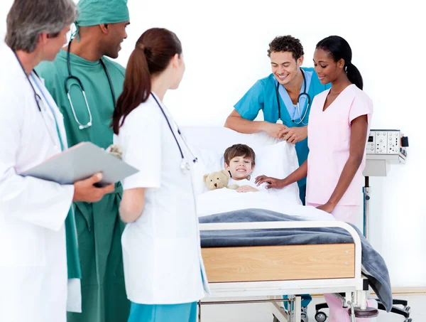 Multi-ethnic medical team taking care of a little boy — Stock Photo, Image