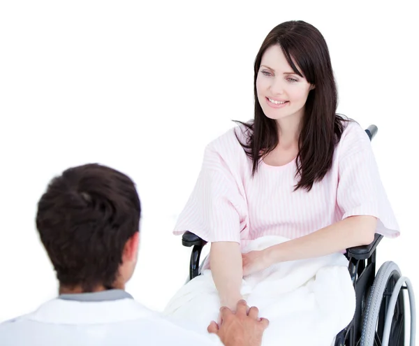 Улыбающаяся пациентка в инвалидном кресле, взаимодействующая со своим доком — стоковое фото