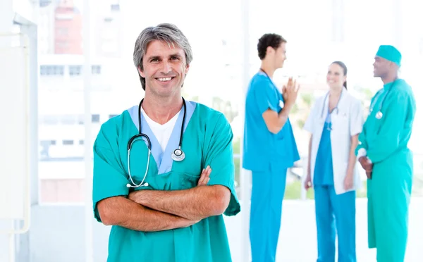 Dojrzały mężczyzna lekarz stojący z zespołem — Zdjęcie stockowe